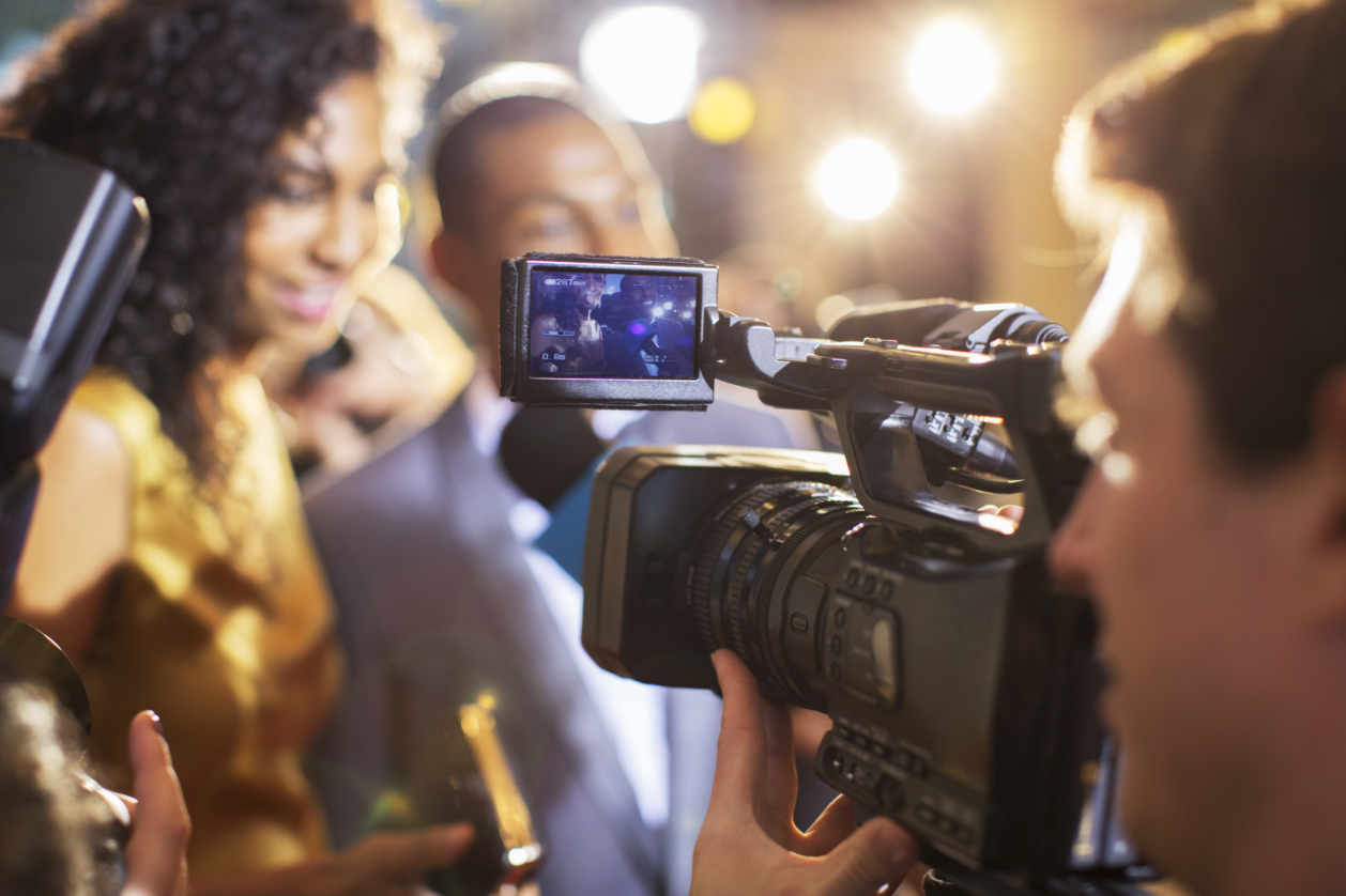 Close up of paparazzi filming celebrity couple at event